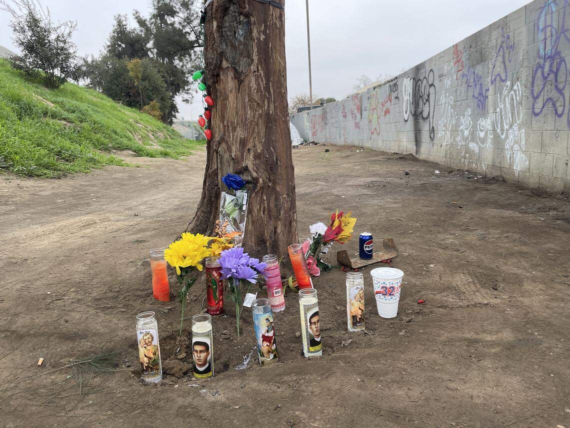 Velas, flores, luces navideñas y otros recuerdos fueron colocados cerca del lugar donde las autoridades encontraron a dos personas sin vida en su tienda en un campamento cerca de Highway 180 en Fresno.