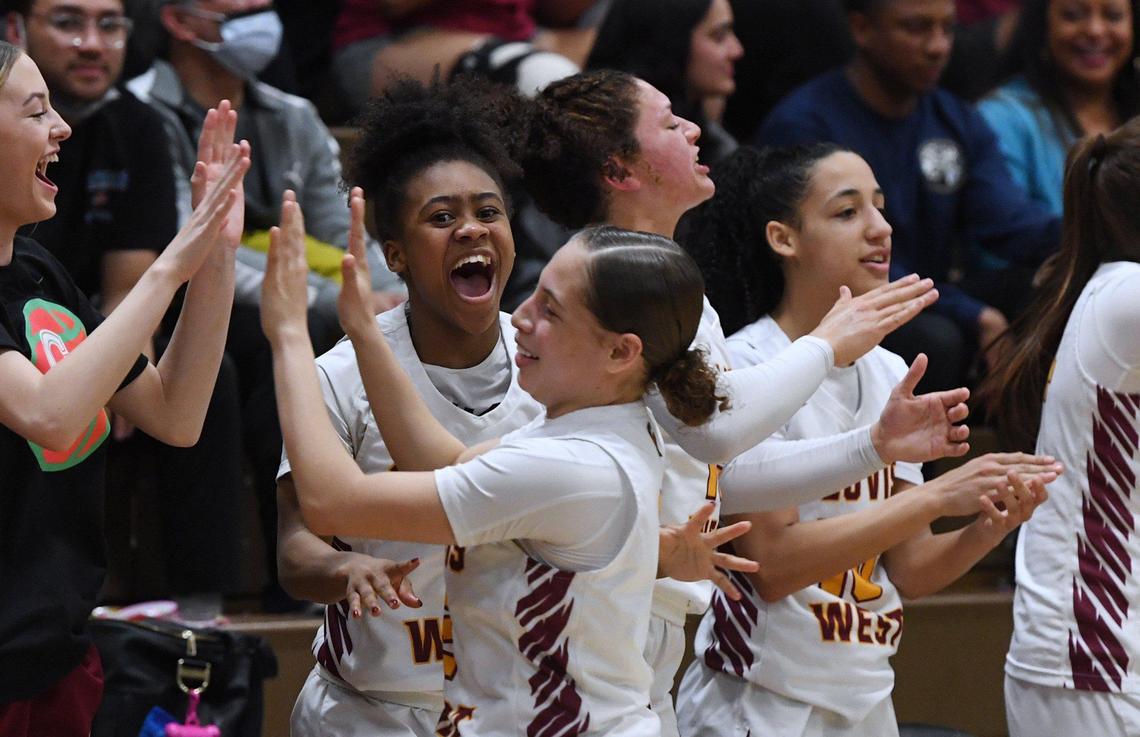 Clovis West’s Athena Tomlinson, center, cheers with the rest of the team as Ariyah Smith walks past foregroundd, during Open Division action against Nipomo Saturday, Feb. 19, 2022 in Fresno. Clovis West toppled Nipomo 68-18.