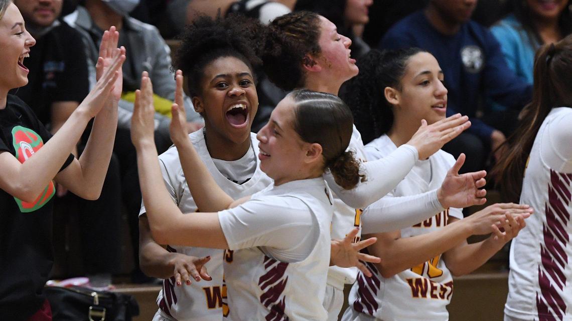 Clovis West’s Athena Tomlinson, center, cheers with the rest of the team as Ariyah Smith walks past foregroundd, during Open Division action against Nipomo Saturday, Feb. 19, 2022 in Fresno. Clovis West toppled Nipomo 68-18.
