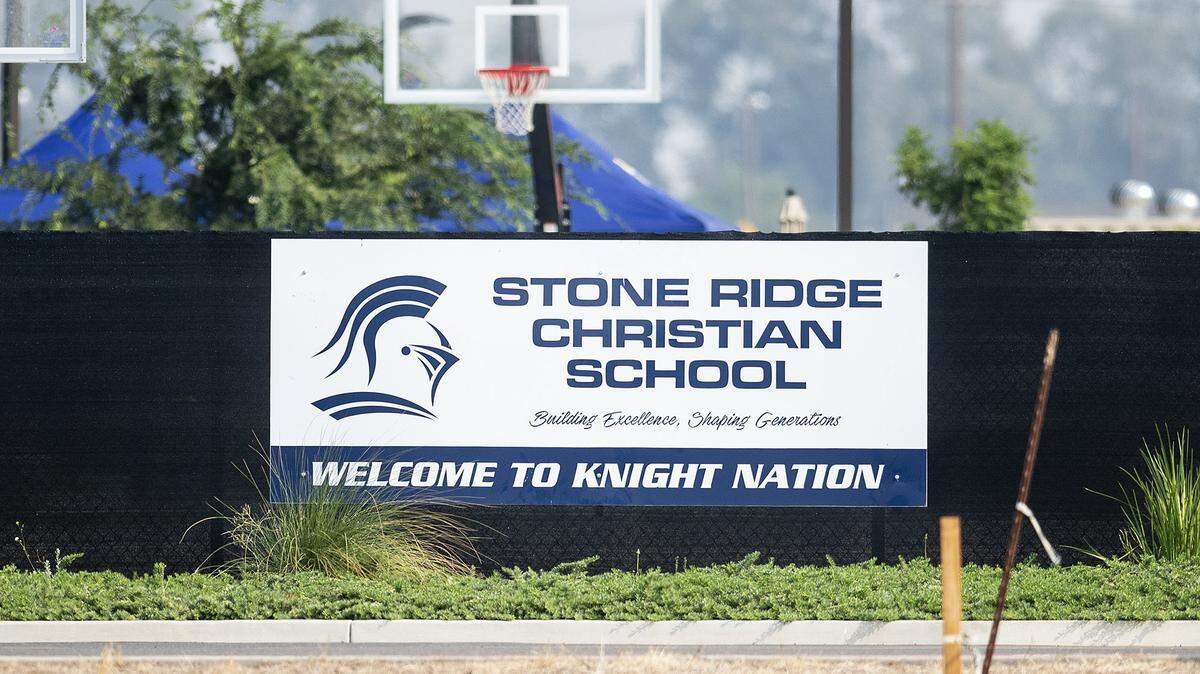 A sign hangs on a fence outside Stone Ridge Christian High School located at 2738 Dan Ward Road in Merced County, Calif., on Tuesday, Aug. 25, 2020.