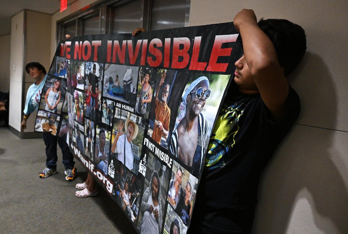 Advocates for the homeless hold a large banner at the rear of the City Council chamber before a special Fresno City Council meeting on a proposed ordinance banning homeless camps on Monday, July 29, 2024 in Fresno.
