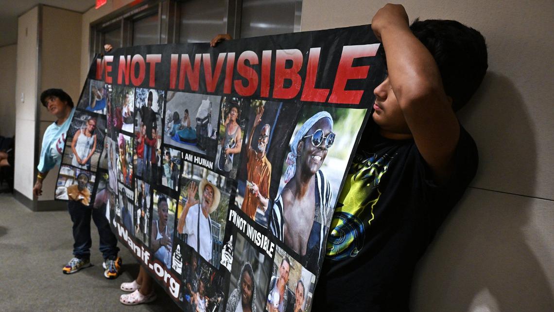 Advocates for the homeless hold a large banner at the rear of the City Council chamber before a special Fresno City Council meeting on a proposed ordinance banning homeless camps on Monday, July 29, 2024 in Fresno.