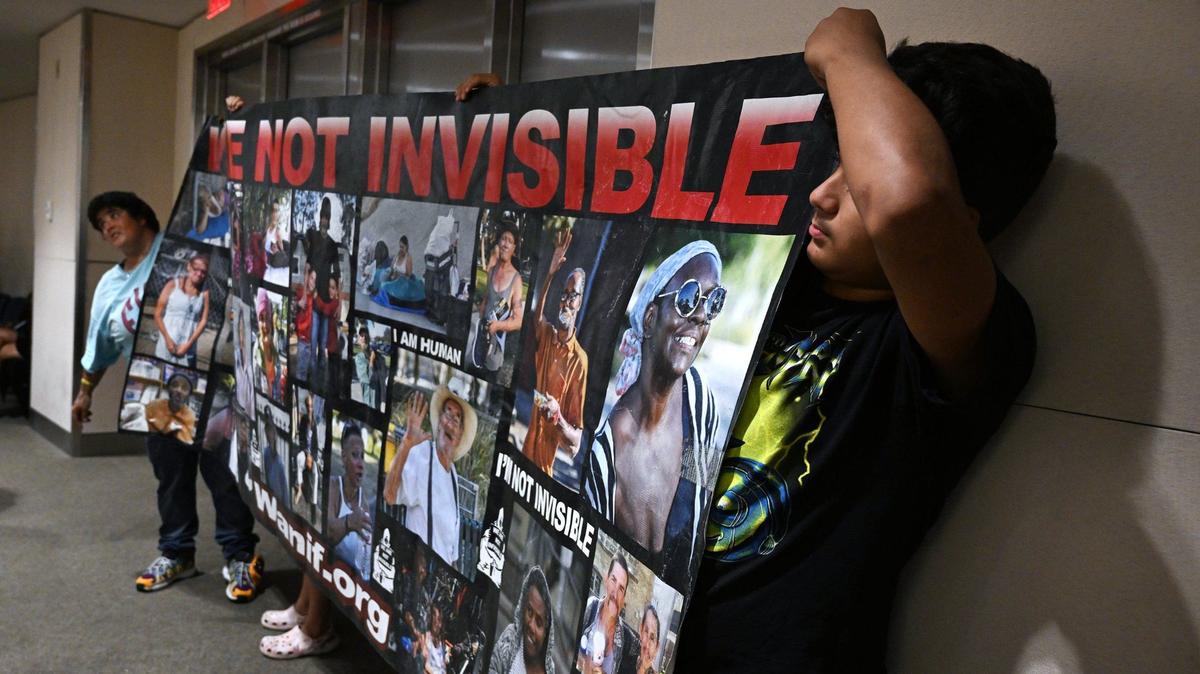 Advocates for the homeless hold a large banner at the rear of the City Council chamber before a special Fresno City Council meeting on a proposed ordinance banning homeless camps on Monday, July 29, 2024 in Fresno.