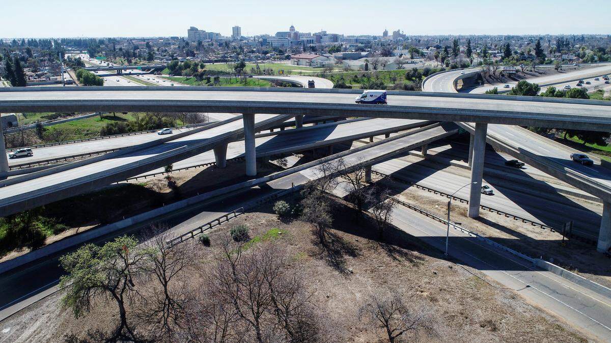 Traffic moves about on the Highway 41 and 180 interchange with downtown Fresno in the background on a warm afternoon, Monday, March 1, 2021. Fresno had minimal rainfall during the month of February.