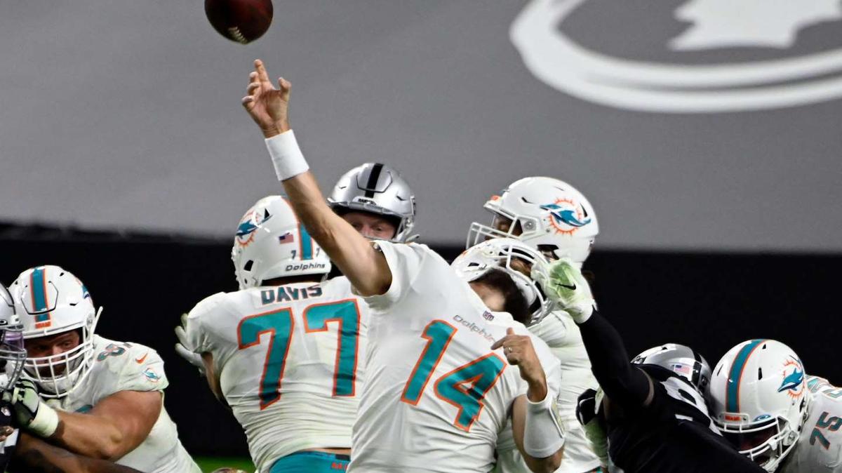 Miami Dolphins’ quarterback Ryan Fitzpatrick fires a pass down field while Las Vegas Raiders’ defensive end has him by the face mask. The play went for a 34-yard gain and with a 15-yard penalty set up a game-winning field goal in the Dolphins’ 26-25 victory Dec. 26, 2020.