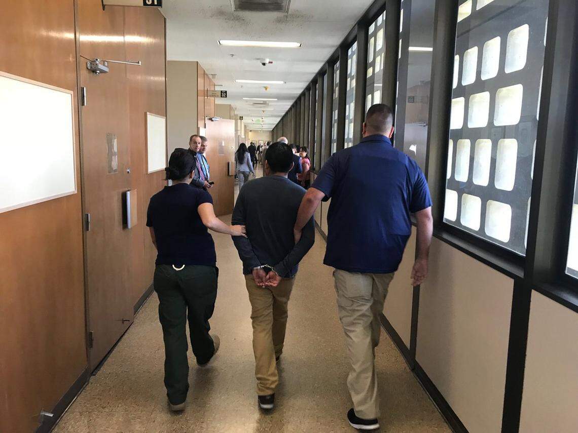 ICE agents are shown leading a suspect down the hall of Fresno County Superior Court on Tuesday.