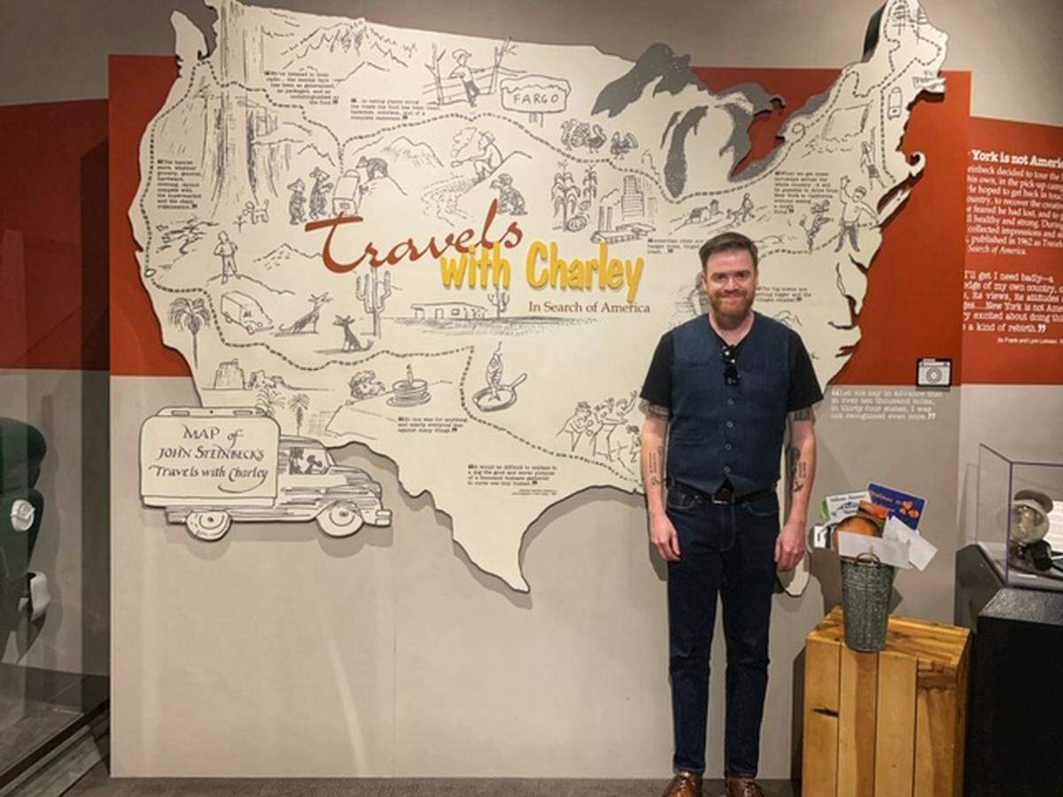 Bryan Starchman in front of map at the National Steinbeck Center in Salinas showing the route author John Steinbeck followed for his book, “Travels with Charley: In Search of America.”