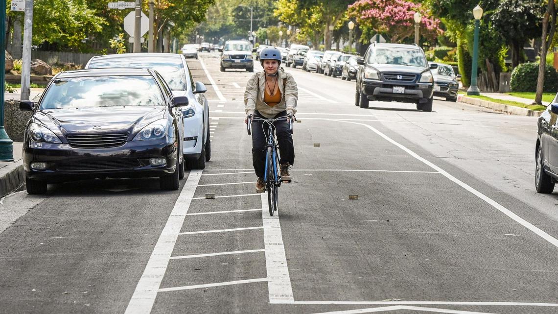 A cyclist navigates around cars parked in the bike lane as opposed to parking spaces next to traffic on Van Ness Avenue near Floradora where new bike lane striping in the area has everyone confused, on Tuesday, Sept. 20, 2022.