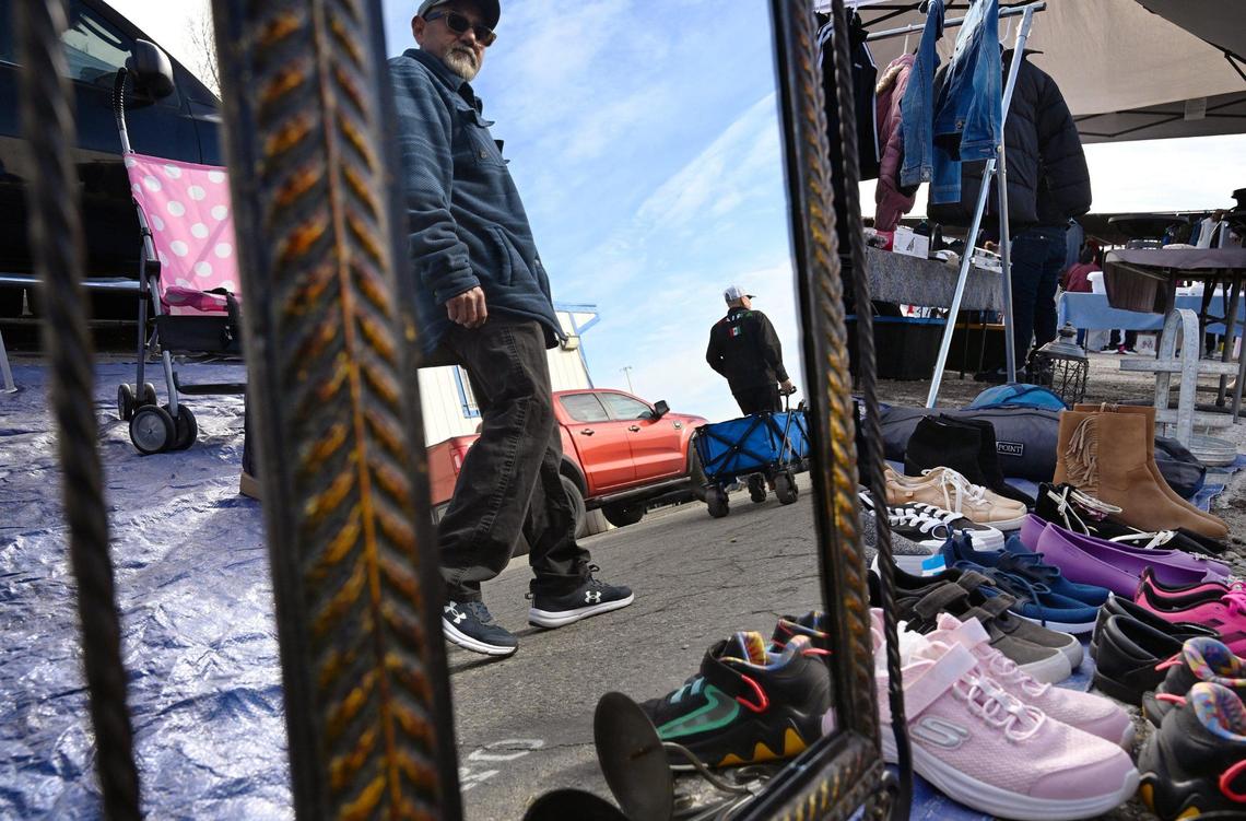 A visitor to the Fresno Flea Market passes a seller of shoes Sunday Feb. 16, 2025 in Fresno.