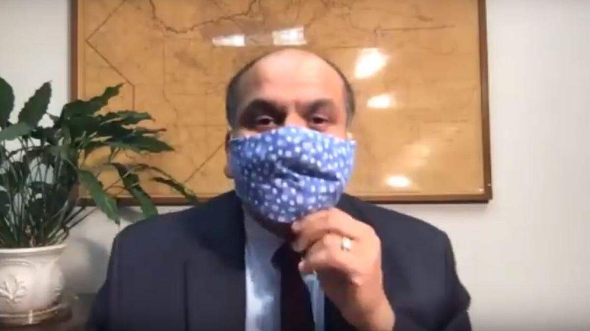 Dr. Rais Vohra, interim health officer for the Fresno County Department of Public Health, dons a fabric mask at the start of a videoconference to provide an update on cononavirus disease cases in the county on Monday, April 6, 2020.