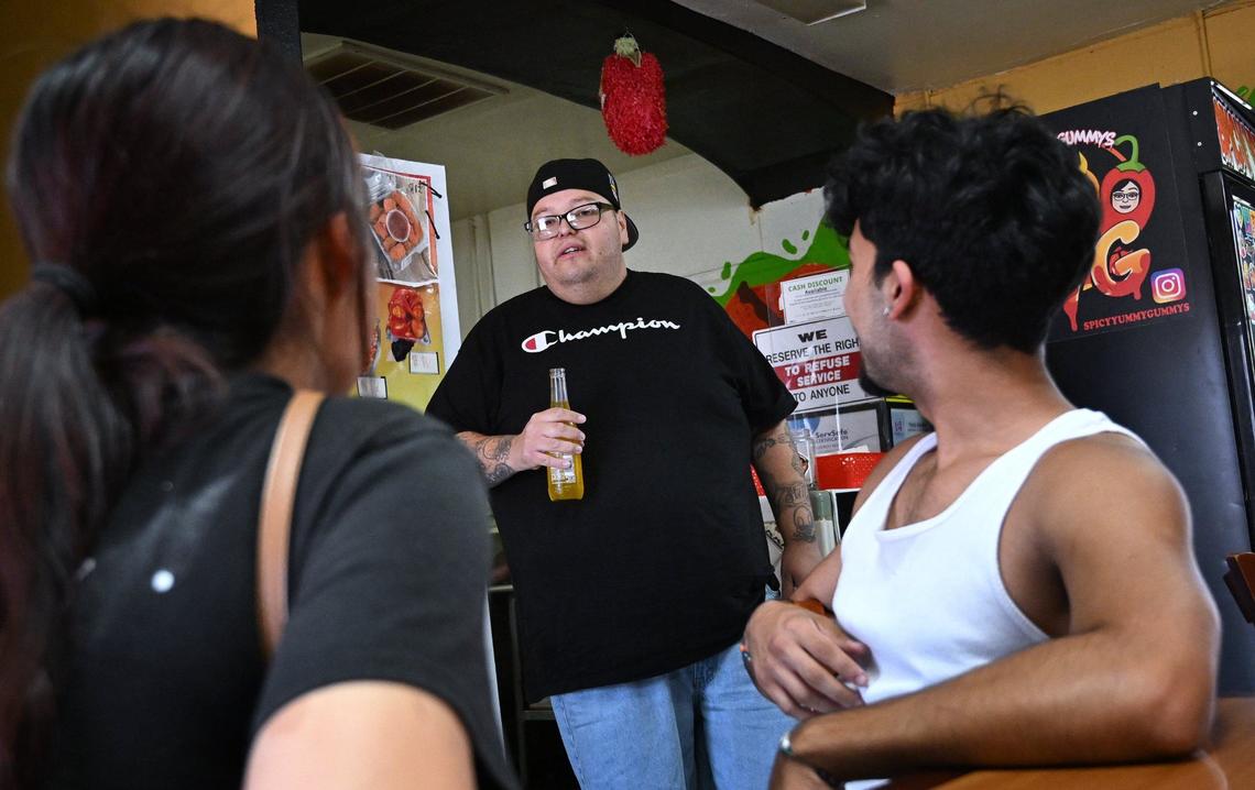 Local food influencer Michael Castillo, best known as Mikey the Foodie Guy on social media, center, talks to new customers at Spicy Yummy Gummys Tuesday, Sept 3, 2024 in Fresno.