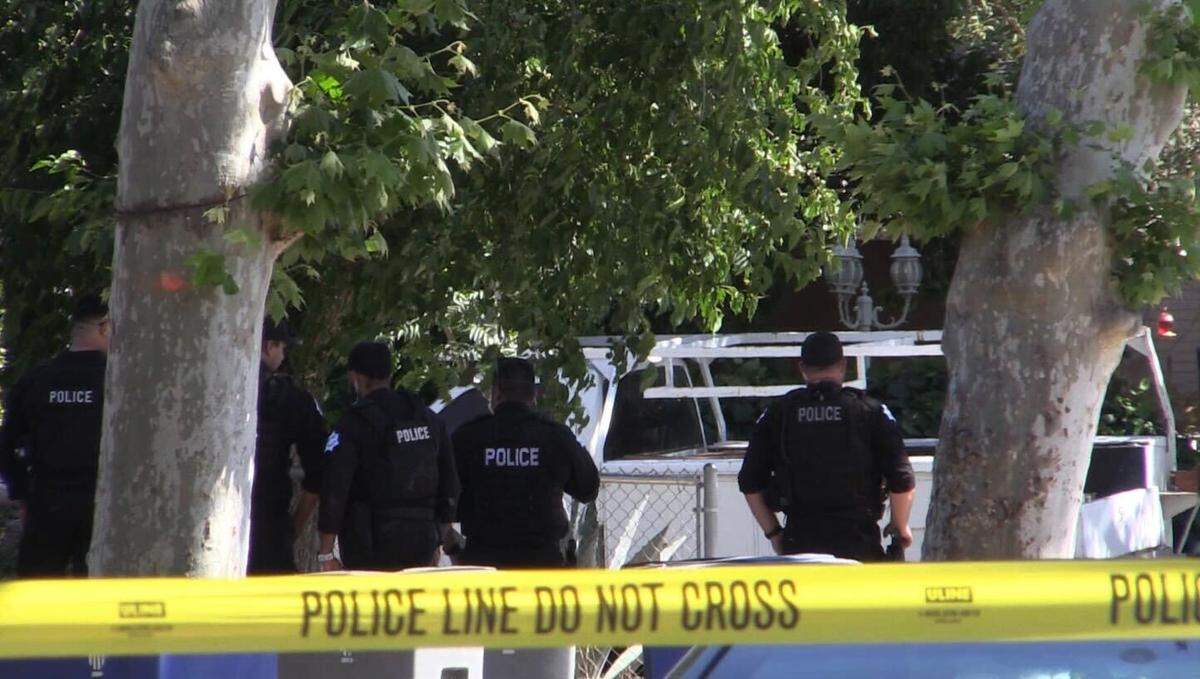 Officers surround a home on South Hayston Avenue in Fresno, California, on Thursday, May 18, 2023.