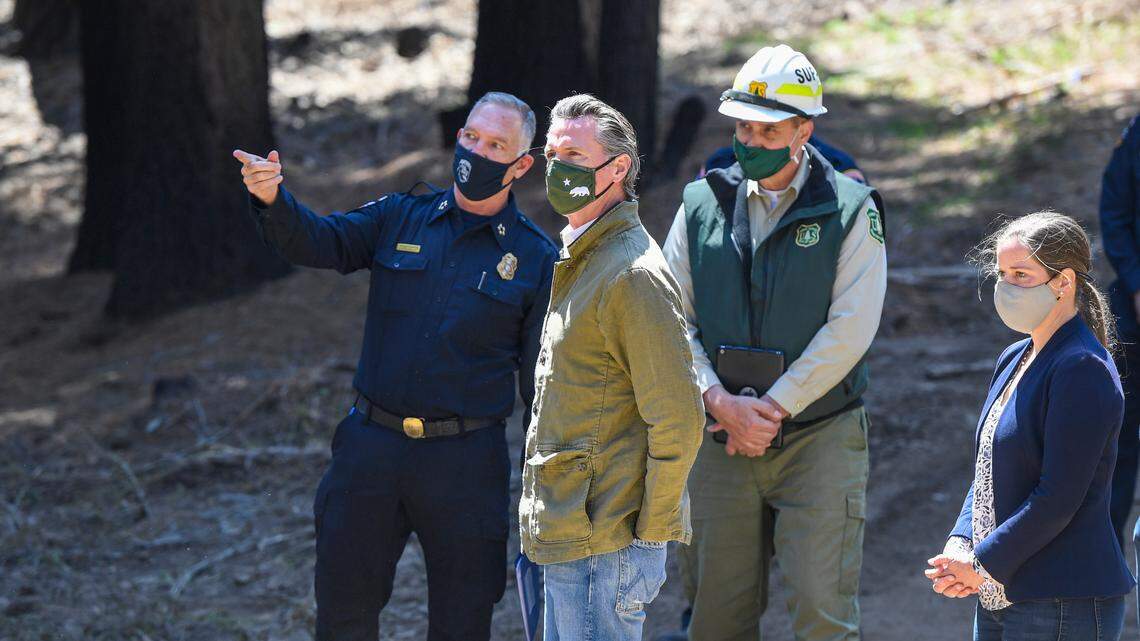 Gov. Gavin Newsom meets with local fire officials while touring an area burned by last year’s Creek Fire near Shaver Lake on Thursday, April 8, 2021.