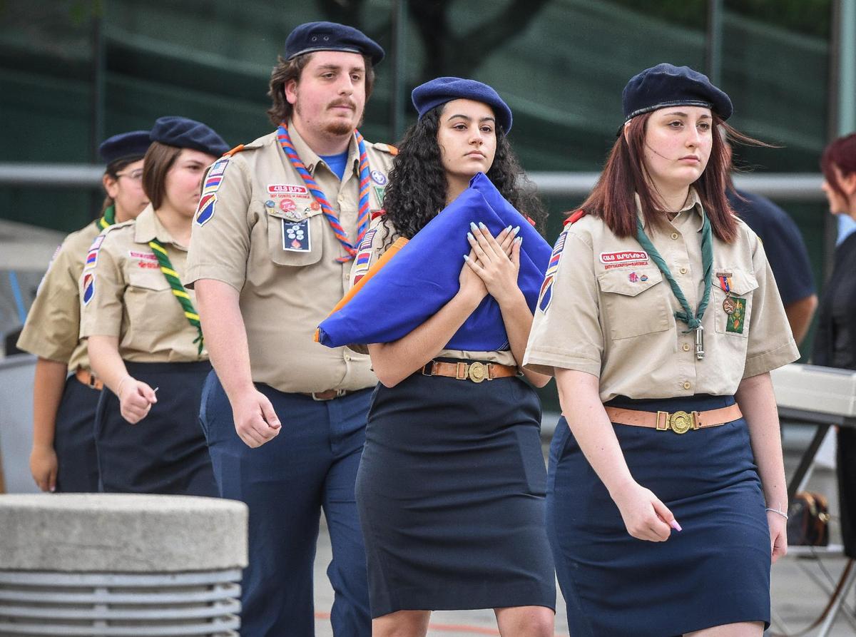 Members of the Homenetmen Fresno Sassoon Chapter scouts carry the Armenian flag toward the flag pole at Fresno City hall during the annual Armenian genocide commemoration and flag raising ceremony on Friday, April 22, 2022.