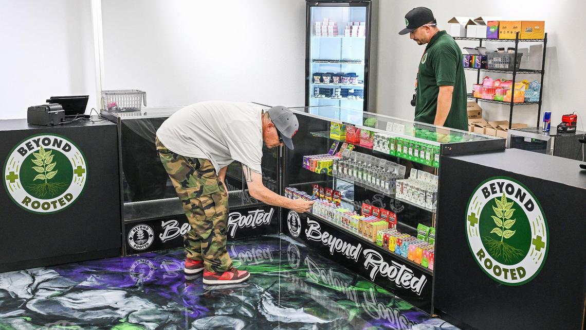 A customer looks over products at Beyond Rooted, a new cannabis dispensary in Fresno, during their soft opening on Thursday, July 3, 2025.