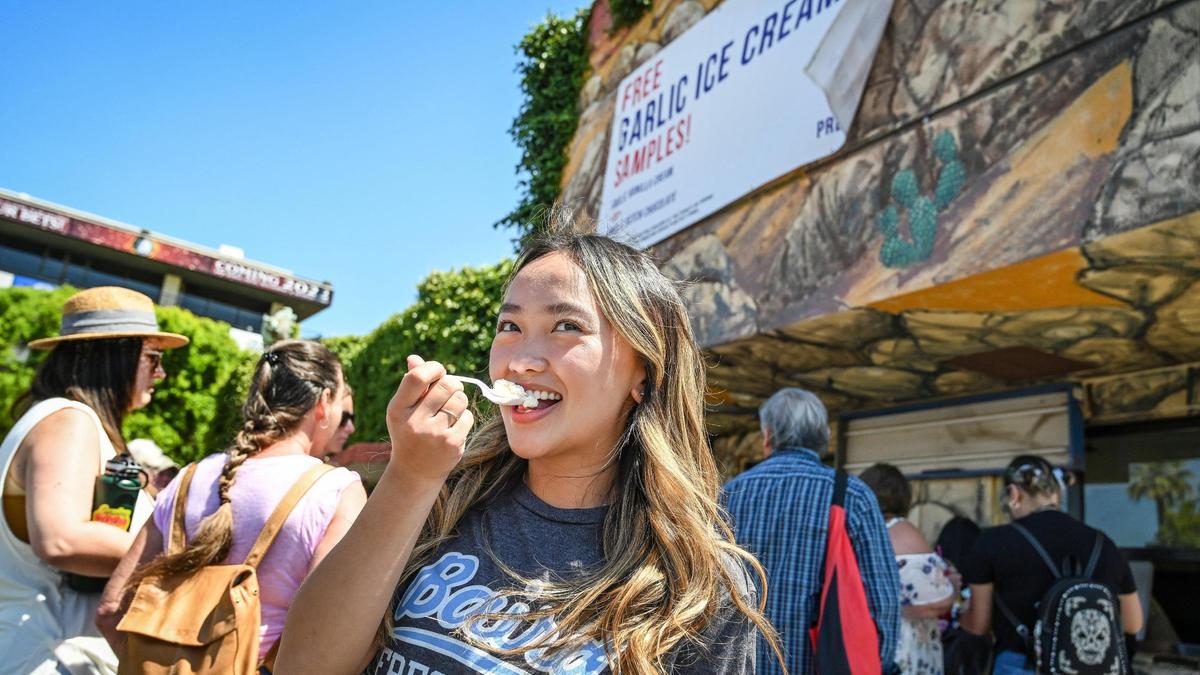 Emily Moua of Fresno takes a taste of garlic ice cream being given out to visitors on day one of the National Garlic Festival at the Fresno Fairgrounds on Friday, May 13, 2022.