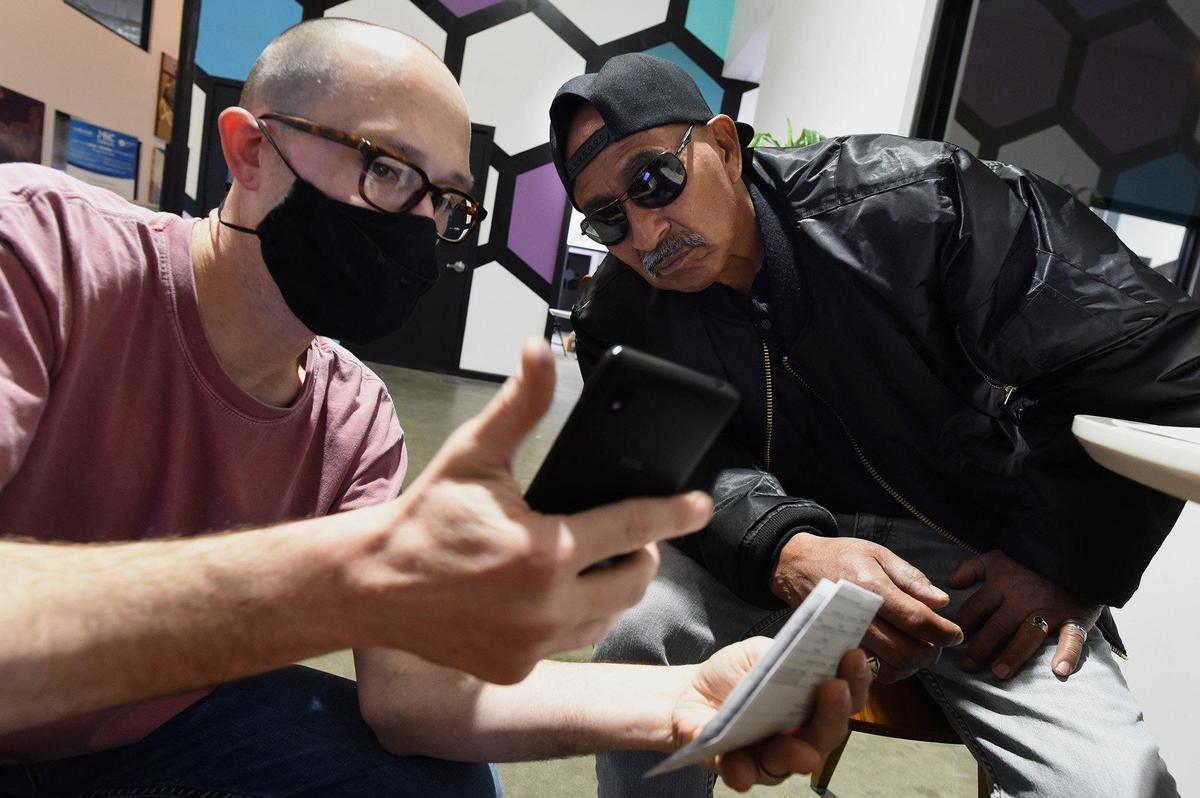 CEO (Center for Employment Opportunities) client Timothy Rodriguez, right, gets help getting set up for filling his taxes, from CEO intake and transition coordinator Justin Marshall, March 11, 2022. Rodriguez, who said he has a lengthy criminal past and incarcerations, credits CEO for turning his life around.