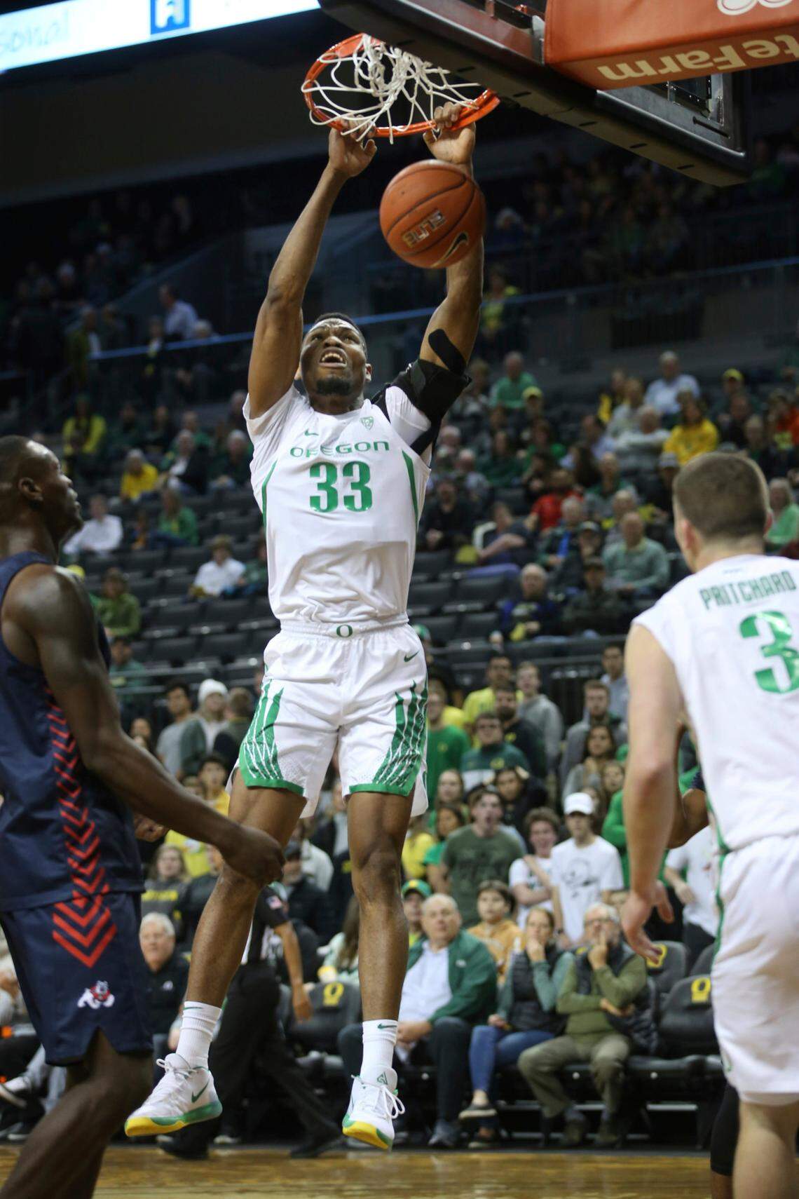 Oregon’s Francis Okoro, center, dunks between Fresno State’s Nate Grimes, left, and Oregon’s Payton Pritchard during the first half of an NCAA college basketball game in Eugene, Ore., Tuesday, Nov. 5, 2019. (AP Photo/Chris Pietsch)