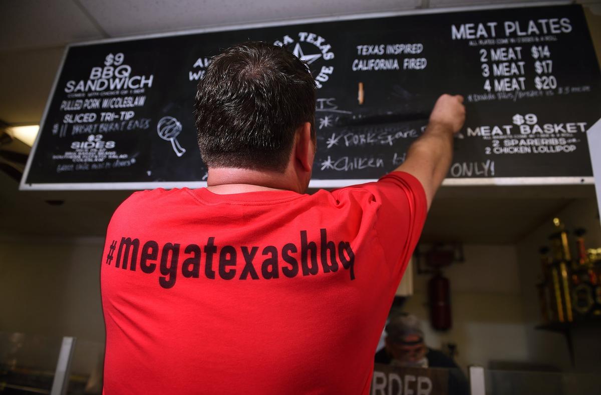 Curtis Hellman adjusts the menu as items run out throughout the day at Mega Texas Barbeque Friday, Feb. 1, 2019 in Fresno.