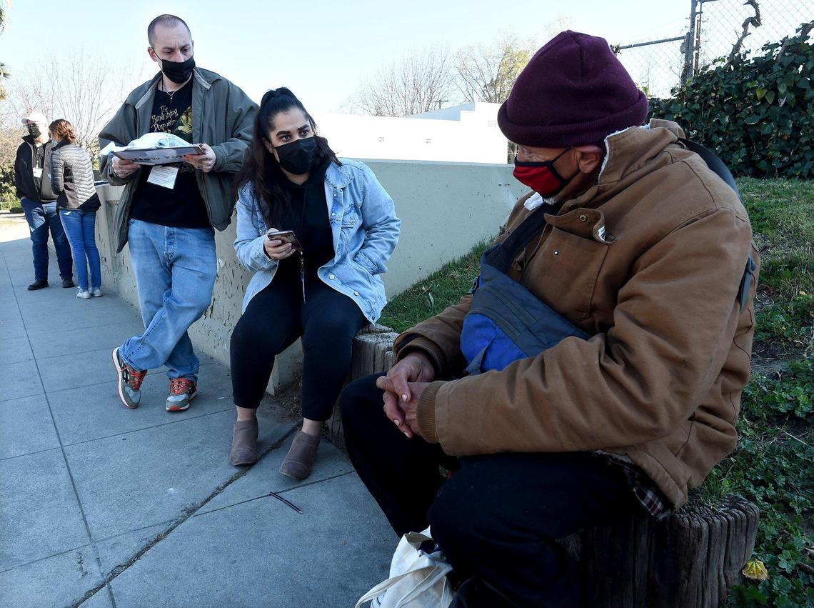 Fresno Madera Continuum of Care volunteers Ashley Morris and Dylan Jenkins, left, interview Gerardo Rodriguez, who is homeless, during the Point in Time count survey in the Tower District, Feb. 25, 2022.