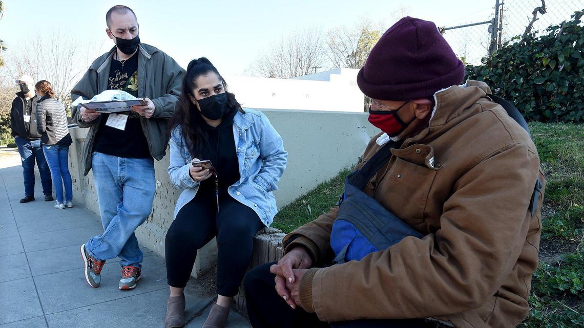 Fresno Madera Continuum of Care volunteers Ashley Morris and Dylan Jenkins, left, interview Gerardo Rodriguez, who is homeless, during the Point in Time count survey in the Tower District, Feb. 25, 2022.