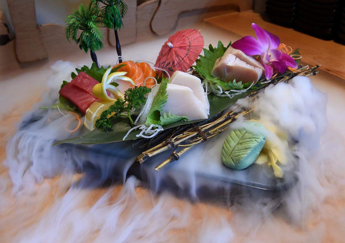 Dry ice vapor flows over an island of sushi at Nami Japanese Cuisine.