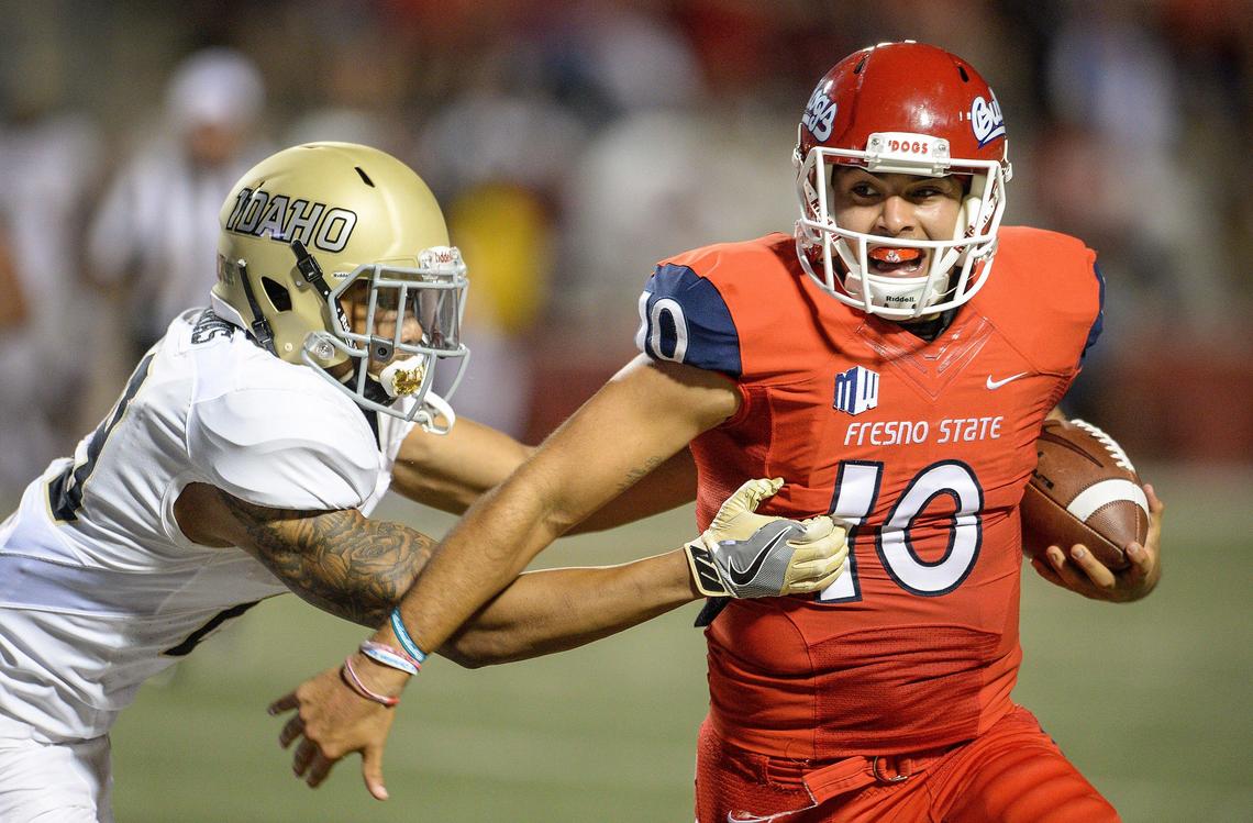 Fresno State quarterback Jorge Reyna, right, runs through a tackle by Idaho’s Sedrick Thomas in the Bulldogs; 79-13 victory over the Vandals at Bulldog Stadium on Saturday, Sept. 1, 2018.