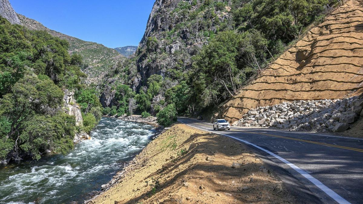 A car drives along Highway 180 near the south fork of the Kings River just west of Boyden Caverns in the Sequoia National Forest where the hillside had been shored up following damage from the 2023 winter on Tuesday, June 11, 2024.