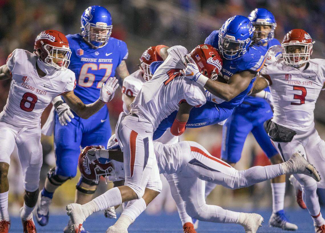Boise State running back Alexander Mattison (22) leaps to avoid Fresno State defensive back Tank Kelly but get smacked by DB Mike Bell in midair in the second quarter Friday, Nov. 9, 2018 at Albertsons Stadium in Boise.