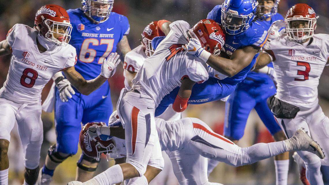 Boise State running back Alexander Mattison (22) leaps to avoid Fresno State defensive back Tank Kelly but get smacked by DB Mike Bell in midair in the second quarter Friday, Nov. 9, 2018 at Albertsons Stadium in Boise.