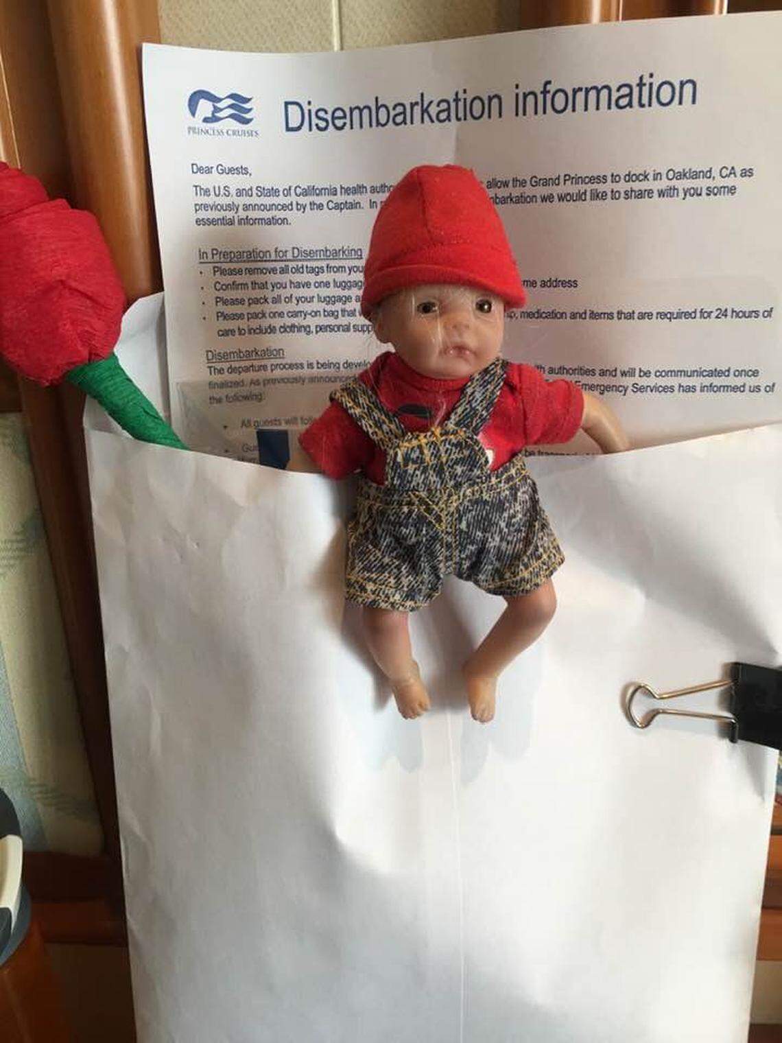 Paula Yost’s plastic baby doll next to information about how to disembark the Grand Princess cruise ship, which docked in the Port of Oakland on March 9, 2020.