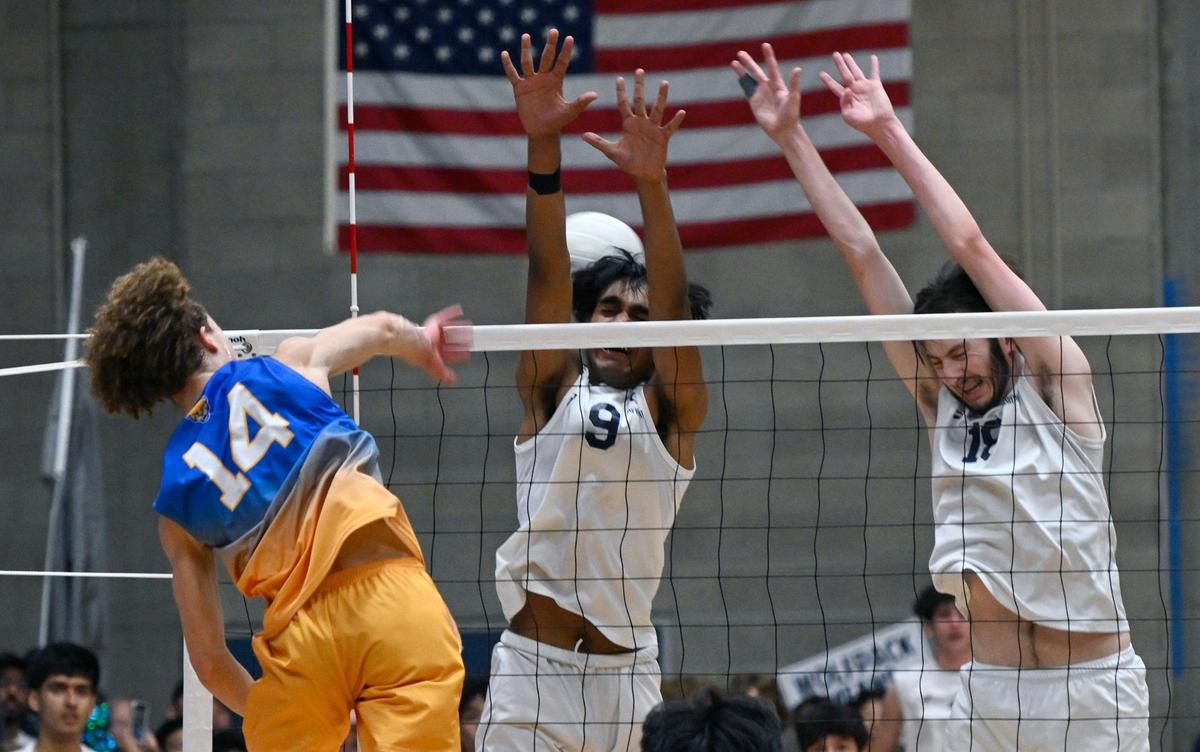 Clovis High’s Brendenn Oneil, left, smashes the ball for a point against Clovis East’s Gurshab Singh, center, and Jacob Shelton, right, in the Central Section Division I volleyball championship Thursday, May 11, 2023 in Clovis.