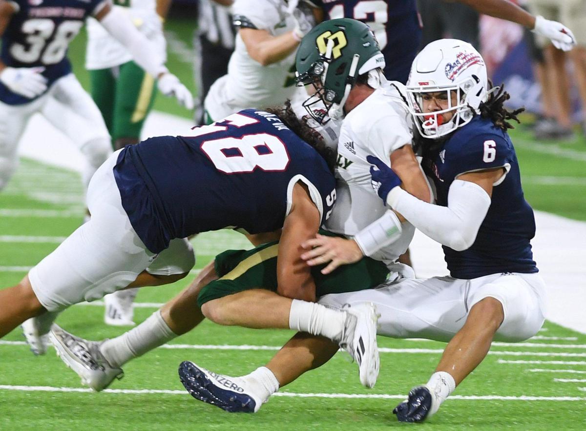 Fresno State linebacker Tyson Maeva, left, and Levelle Bailey, right, put the squeeze on Cal Poly quarterback Spencer Brasch in the Bulldogs’ 63-10 victory over the Mustangs Saturday, Sept. 11, 2021 in Fresno.