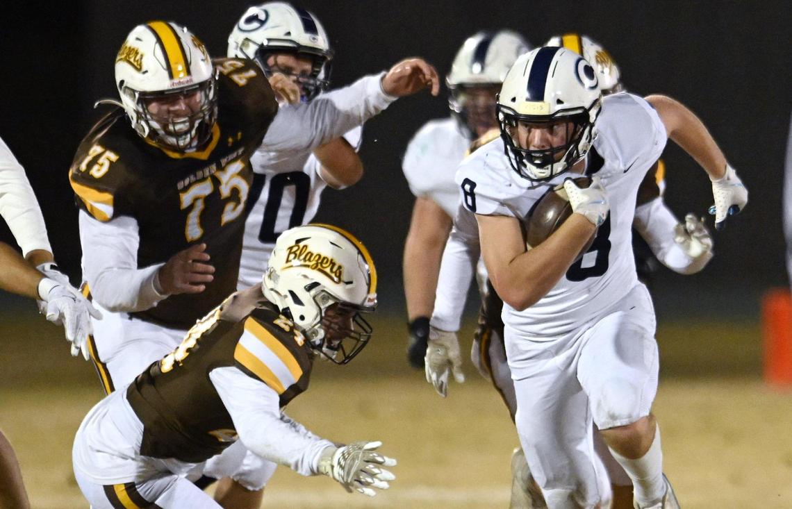 Central Valley Christian’s Josh Hilvers, right, is chased by Golden West’s defense in the D2 semifinal championship game Friday night, Nov. 22, 2024 in Visalia.