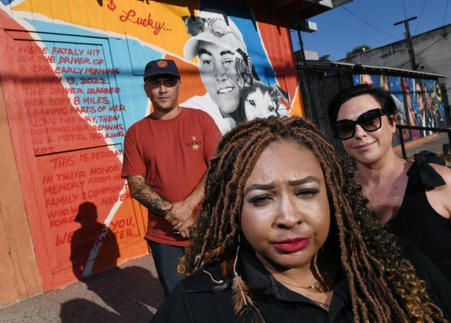 Janay E. Conley, center, stands with mural artist Eric Olage, left, and Danielle Carlson, right, in front of the new mural honoring Monique Contreraz and her dog Lucky in the Tower District Tuesday, July 26, 2022 in Fresno. Contreraz was killed after being dragged 8 miles by a motorist earlier this year. The mural, created by Eric Olage, stands near Pine and Maroa avenues.