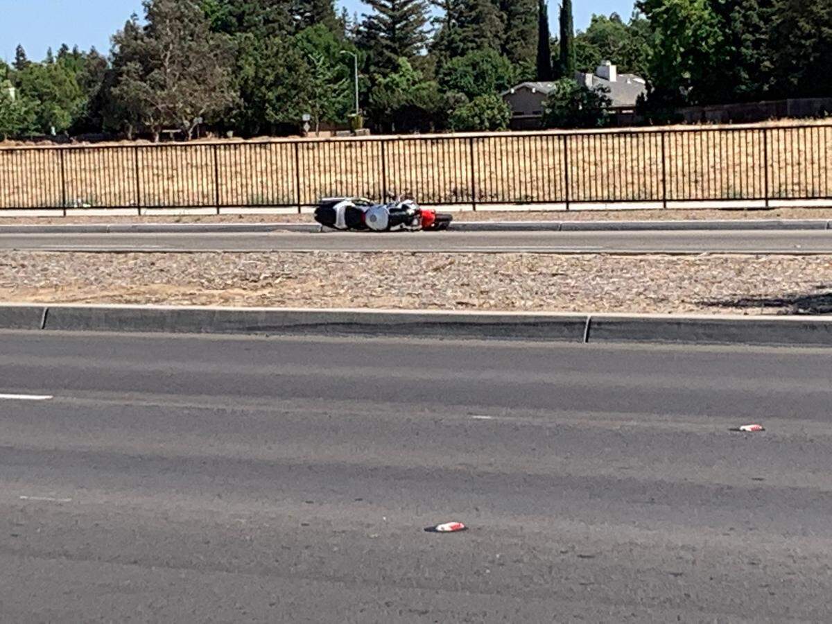 A motorcycle rests on its side along Herndon Avenue after a crash in which the motorcyclist died Sunday afternoon, May 23, 2021, in Fresno, California.