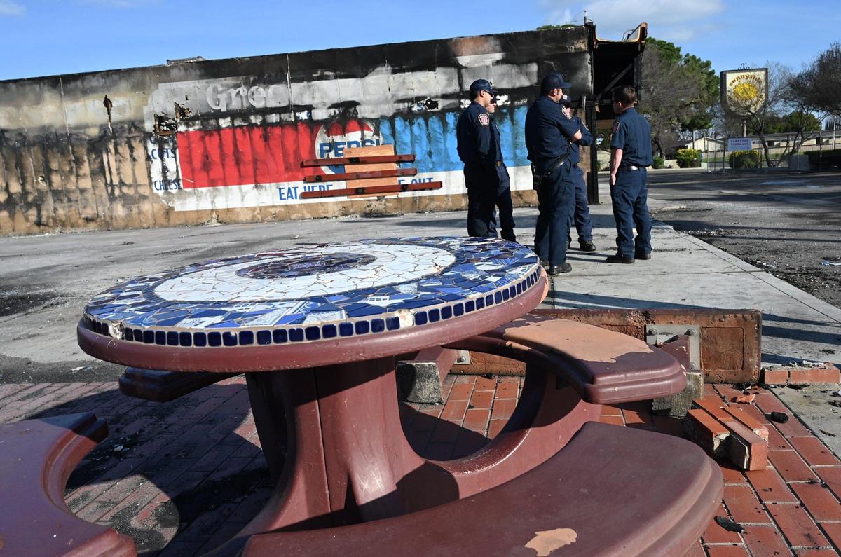Fresno Fire Department personnel stand in the background after Valley Crime Stoppers President Dale Mendoza announces an increase of a reward to $5,000 for information about the fire that consumed several businesses in a strip mall near Kings Canyon and Clovis avenues during a press conference at the site Wednesday, Jan. 18, 2023 in Fresno.