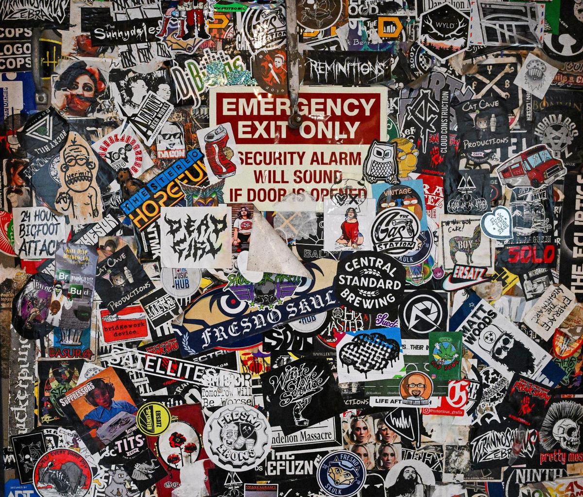 Various stickers from local bands, beers and other groups still cover the back door at what is now Summer Fox, located in the old Club Fred and Audie’s Olympic in the Van Ness Village area of the Tower District in Fresno.