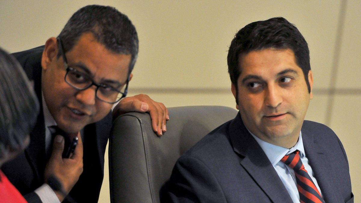Fresno City Councilmember Mike Karbassi, right, listens to Councilmember Miguel Arias and City Clerk Yvonne Spence on the dais.