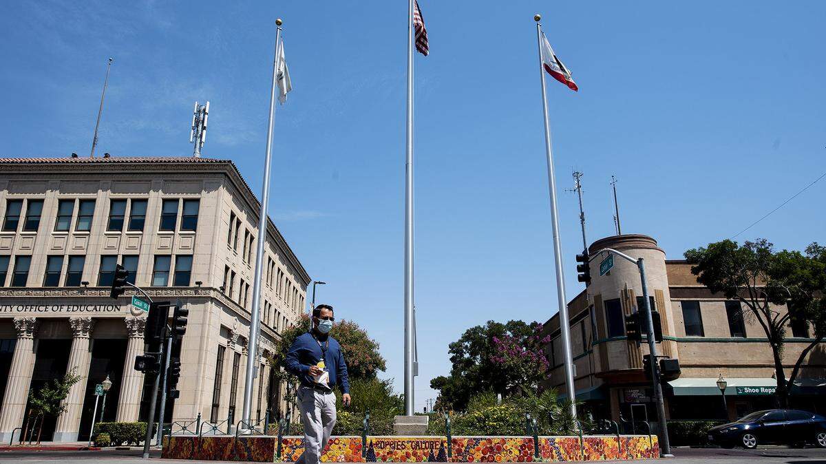 People walk through Bob Hart Square in downtown Merced, Calif., on Monday, Aug. 17, 2020.