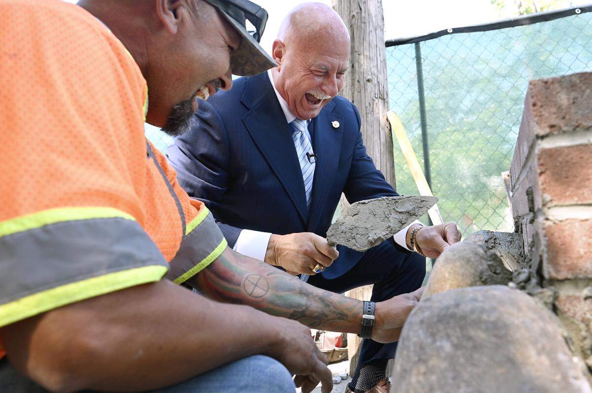 Mayor Jerry Dyer, center, helps place river rock at the base of a historical pillar at SImpson and Palm avenues which was destroyed by a drunk driver last December, during an event held Tuesday, May 19, 2026 in Fresno.