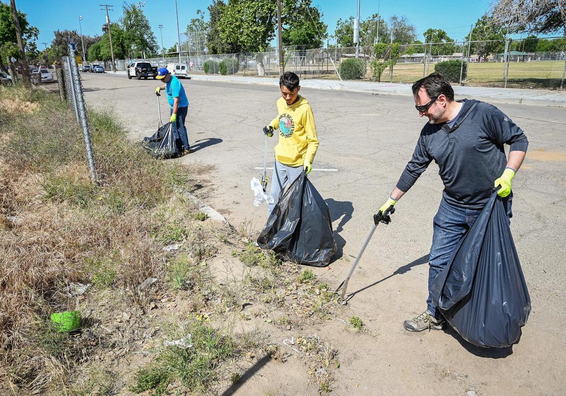 The Fresno Bee’s Marek Warszawski, left, and Joe Kieta, right, and Joe’s son Ethan participate in Beautify Fresno’s Great American Cleanup event near Fink-White Park in Fresno on Saturday, April 30, 2022.
