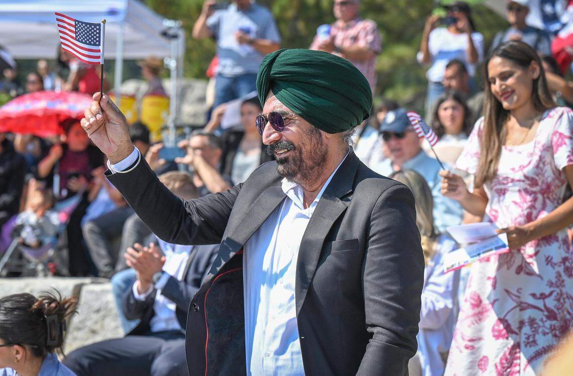 Swaran Grewal of Fresno, an immigrant from India, waves an American flag during a naturalization ceremony that was held at Glacier Point in Yosemite National Park to commemorate Constitution Day and Citizenship Day on Wednesday, Sept. 17, 2025. 