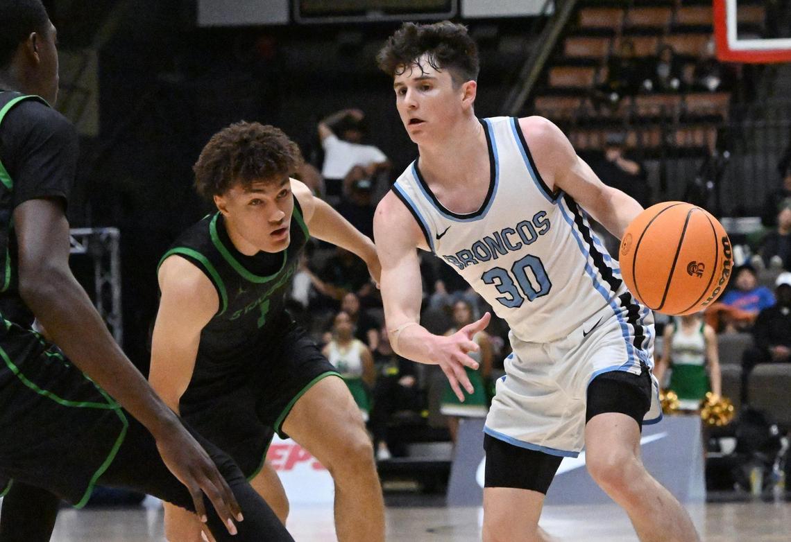 Clovis North’s Connor Amundsen, right, with St. Joseph’s Julies Price to the left in the Central Section Division I basketball championship Saturday, Feb. 24, 2024 at Selland Arena in Fresno.