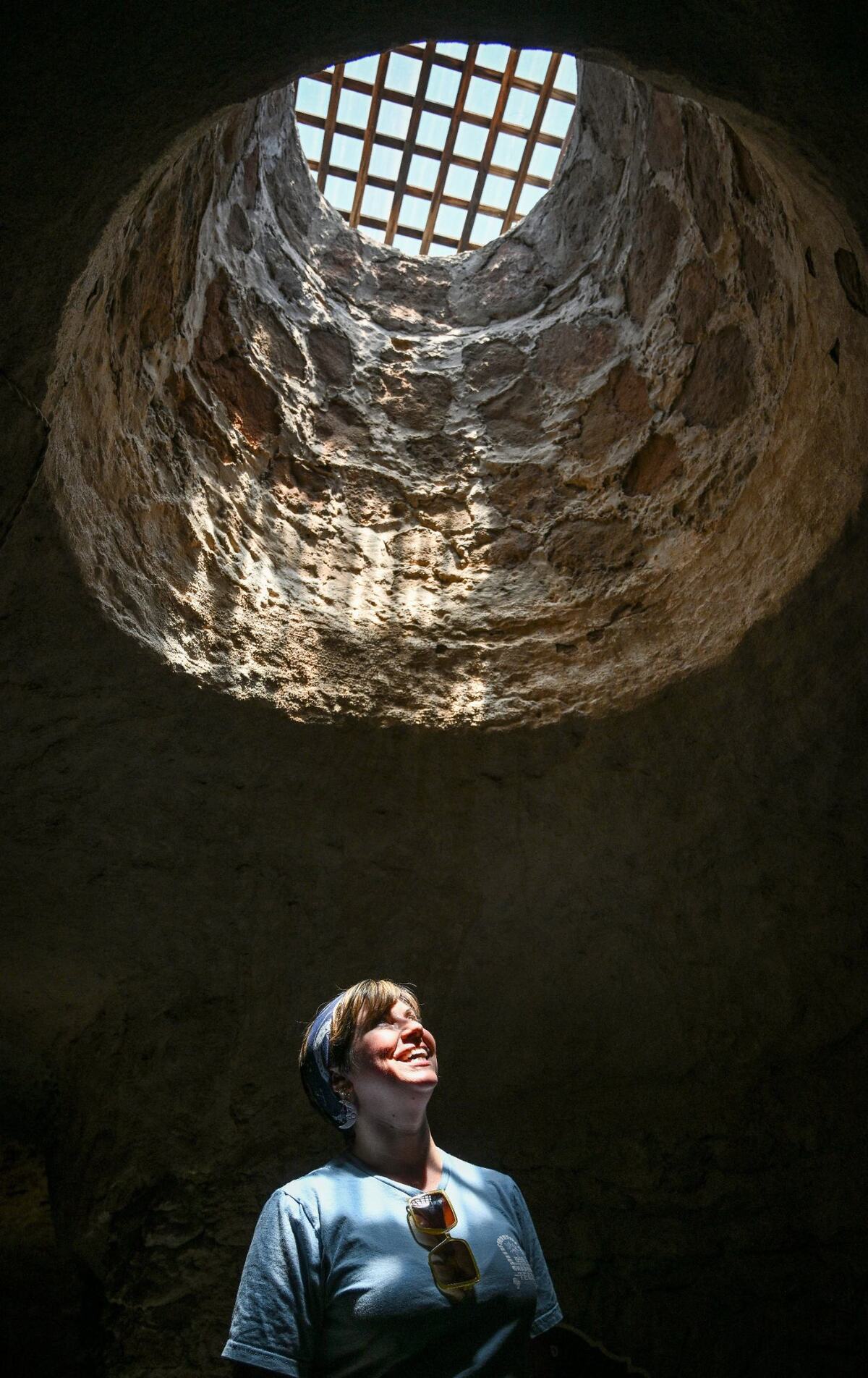 Shera Franzman, director of operations at the Forestiere Underground Gardens in Fresno, keeps cool below ground while looking up into one of the gardens many skylight openings on Monday, July 22, 2024.