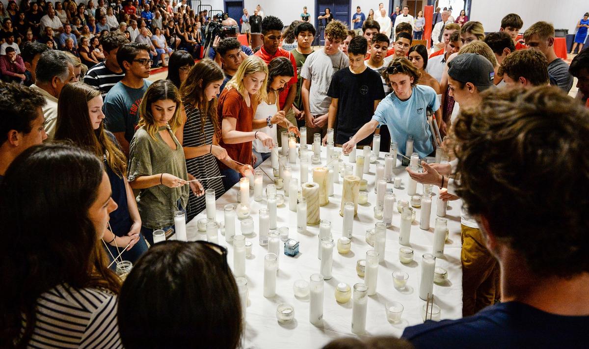 Students, family, friends and faculty gather to light candles during a prayer vigil for San Joaquin Memorial High School student Nick Kauls at the school's gym on Tuesday, June 26, 2018.