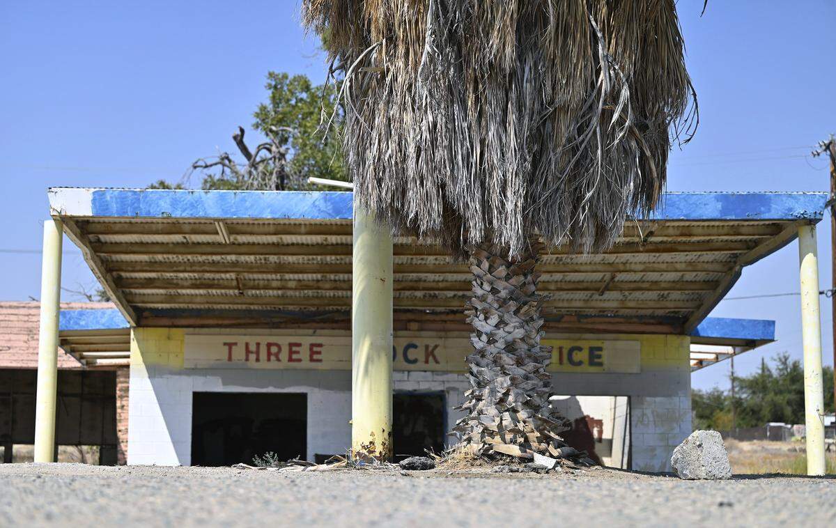 An abandoned auto repair shop in Three Rocks has sunk as a result of subsidence, one of many factors also affecting California's Aqueduct. Photographed Monday, Aug. 11, 2025.