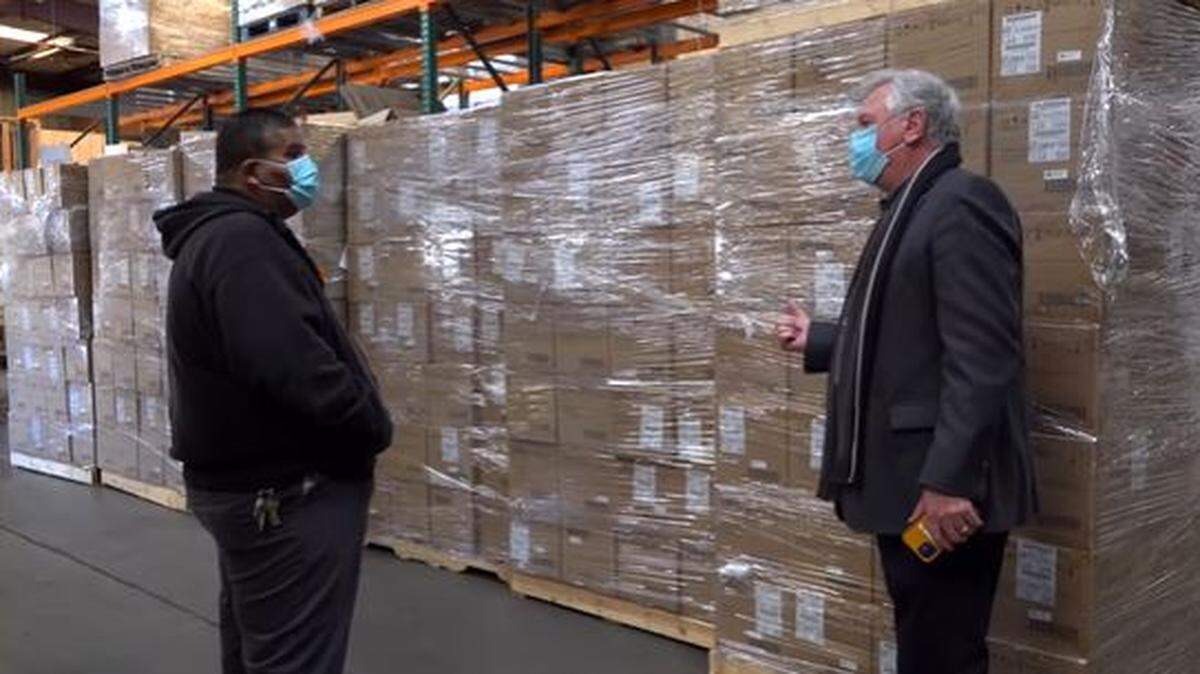 Merced County Office of Education Superintendent of Schools Steve Tietjen, right, is shown speaking to an employee in front of a recent delivery of COVID rapid test kits.