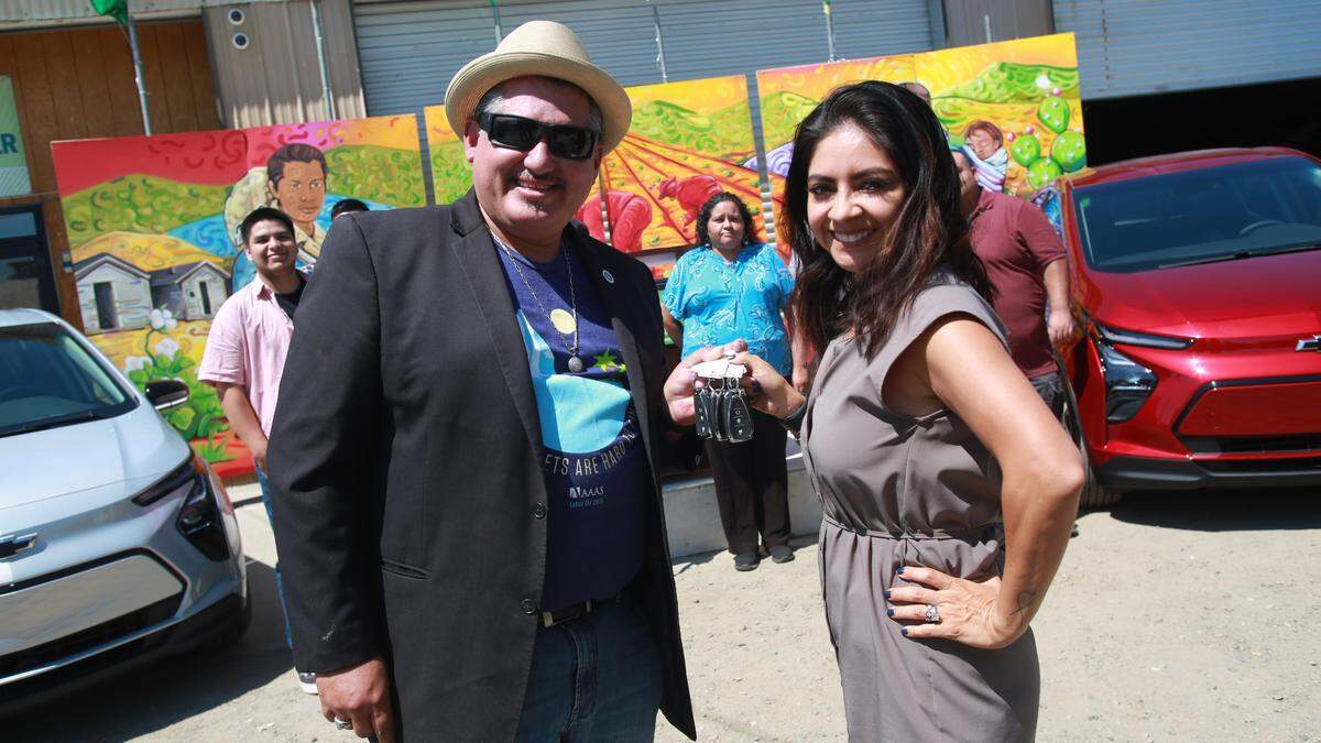 Huron Mayor Rey León, who is also executive director of the LEAP Institute with General Motors regional director Juanita Martínez with the keys of the four Chevrolet Bolt electric vehicles provided by GM as a loan for six months to increase equitable access to COVID-19 vaccinations and testing by expanding sustainable transportation options to Fresno County farmworkers and their families.