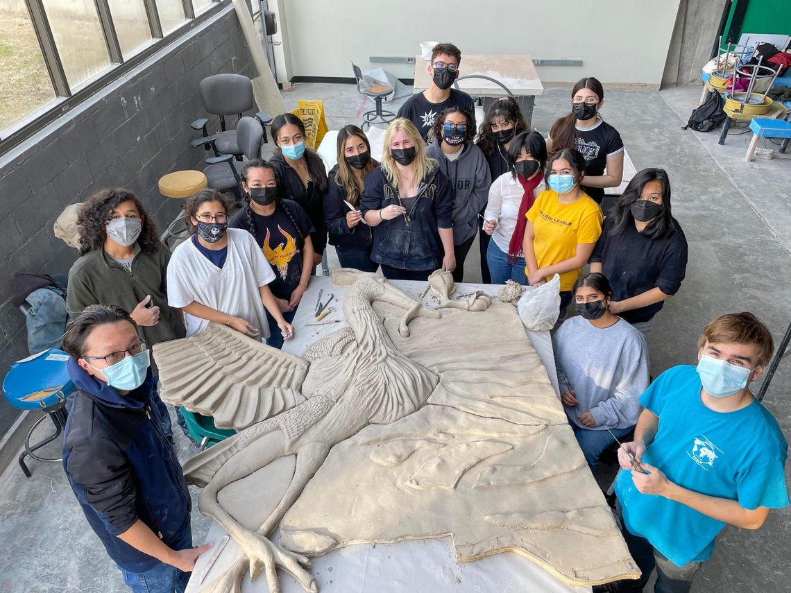 A photo shows University High School students working on a great blue heron ceramic mural spearheaded by Fresno artist David Roberts in 2022.
